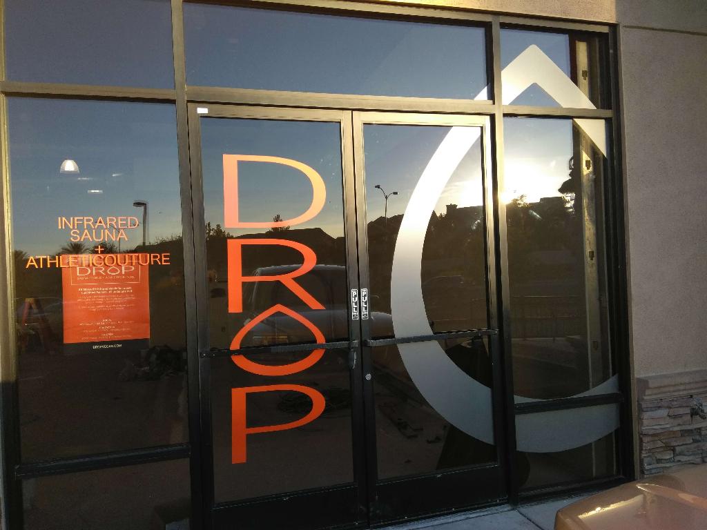 storefront window graphics Drop storefront window graphics: tall orange letters and a frosted logo on the glass doors
