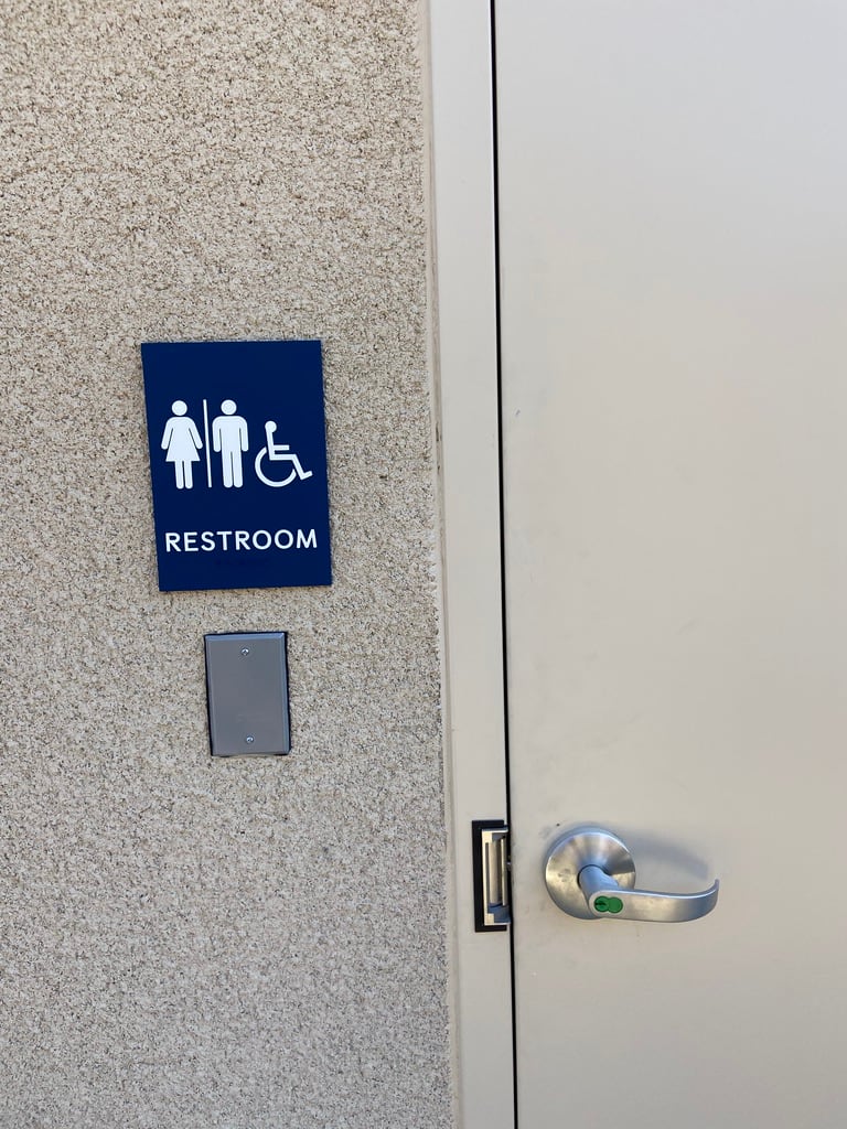 ada restroom sign ADA restroom sign with women's, men's and accessible pictograms beside a door