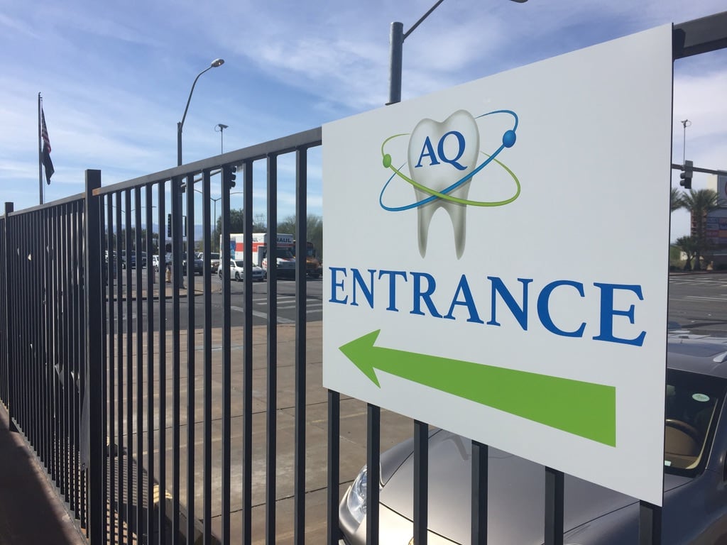 outdoor directional sign AQ entrance directional sign with a green arrow on a fence