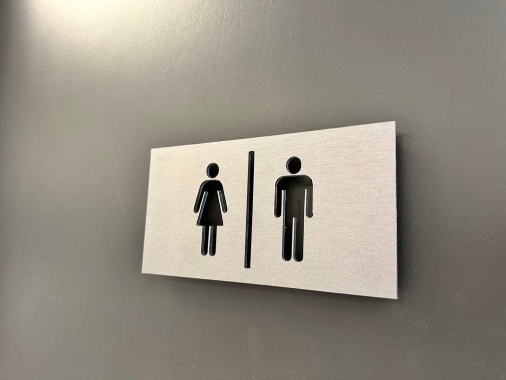restroom sign Restroom sign with women's and men's pictograms on a brushed aluminum panel