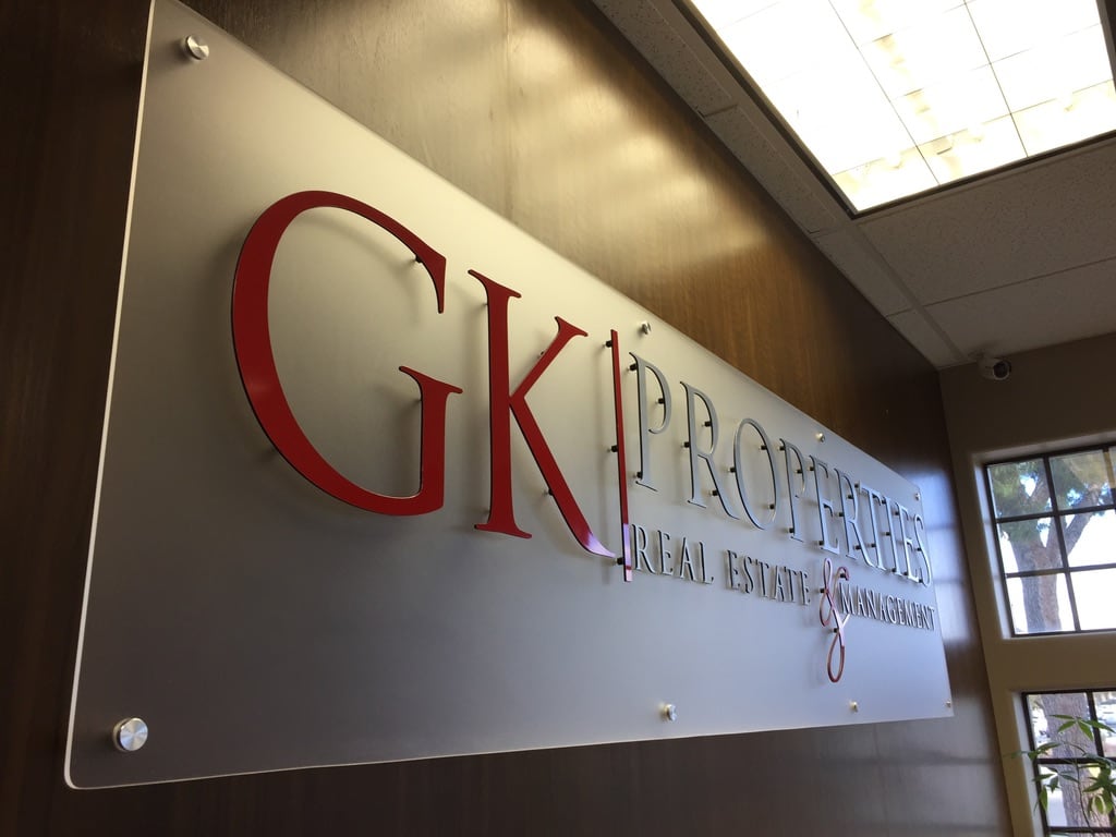 acrylic lobby sign GK Properties lobby sign: red and silver letters on a frosted acrylic panel