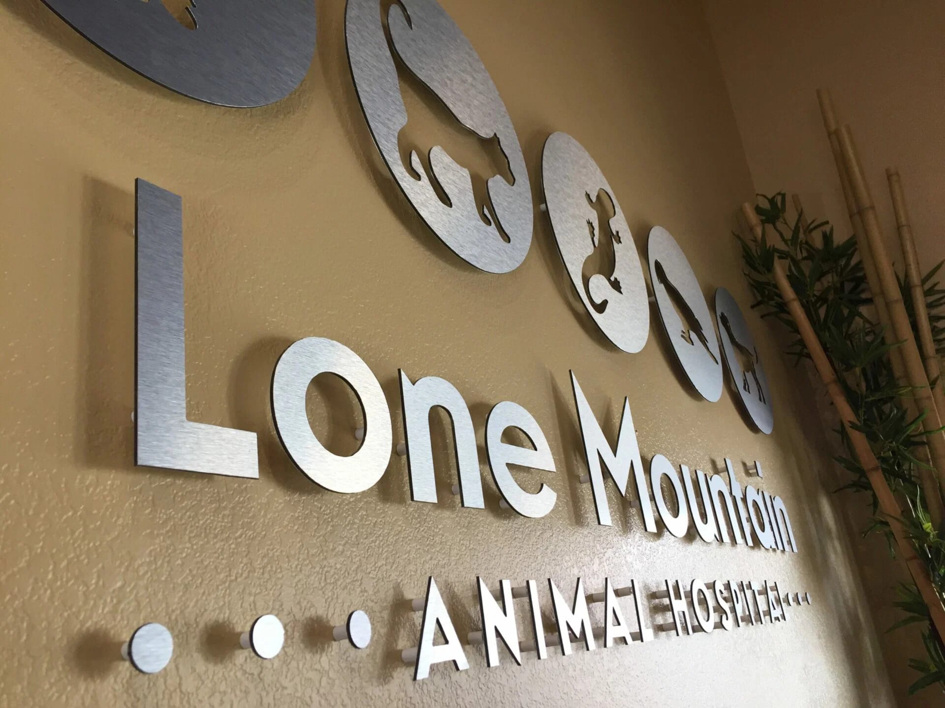 brushed metal lobby sign las vegas Lone Mountain Animal Hospital lobby sign: brushed metal letters and animal cutout discs on standoffs
