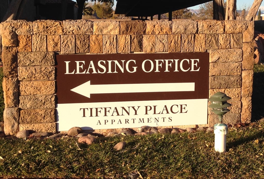 apartment complex monument sign las vegas Tiffany Place Apartments leasing office sign with a directional arrow on a stone monument wall